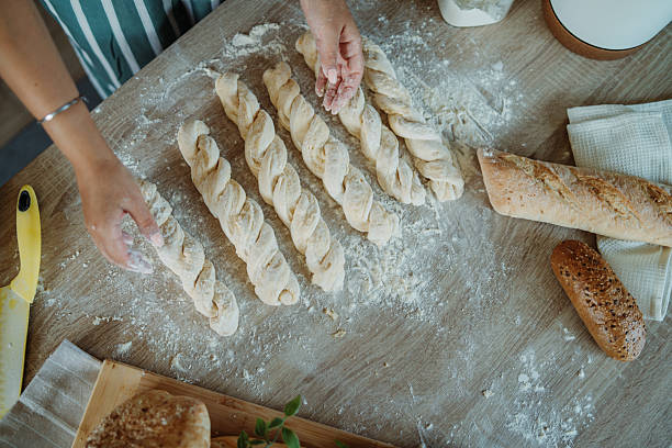 istock Young caucasian woman making bread dough in her kitchen 2220285731