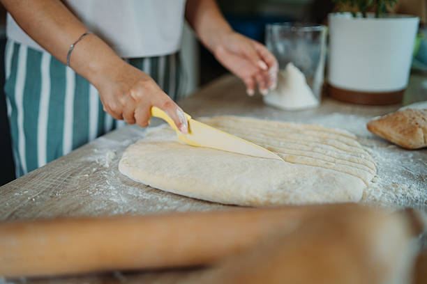 istock Young caucasian woman making bread dough in her kitchen 2220285732