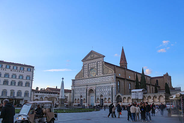Florence, Italy - March 2025: People at the Piazza Santa Maria Novella, around sunset. Santa Maria Novella was the first great basilica of Florence and was  completed in 1470 by Leon Battista Alberti.