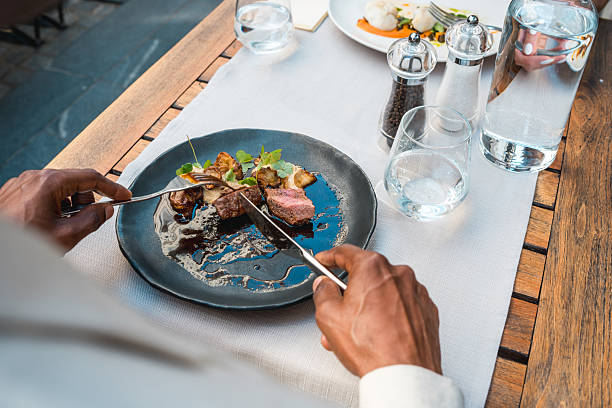 istock Elegant Fine Dining with Gourmet Dish on Rustic Wooden Table in Bright Outdoor Setting 2220290328