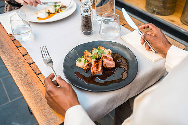 istock Elegant Fine Dining Table Setting with Succulent Dish and Person Enjoying Gourmet Meal Outdoors 2220290339