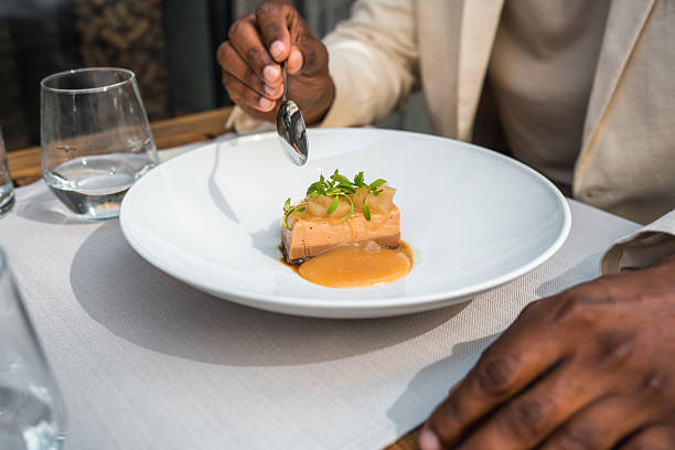 close up of Foie Gras with Caramelised Apple with black vinegar sauce on a white plate