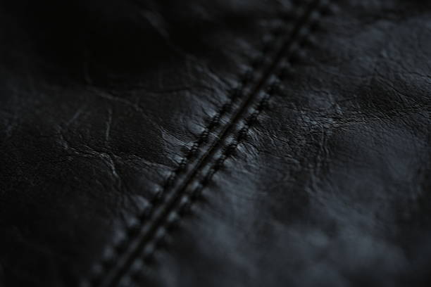 istock black leather jacket close up, macro black leather jacket texture, soft yet rugged, capturing the grain and stitch details with a worn-in feel 2220295944