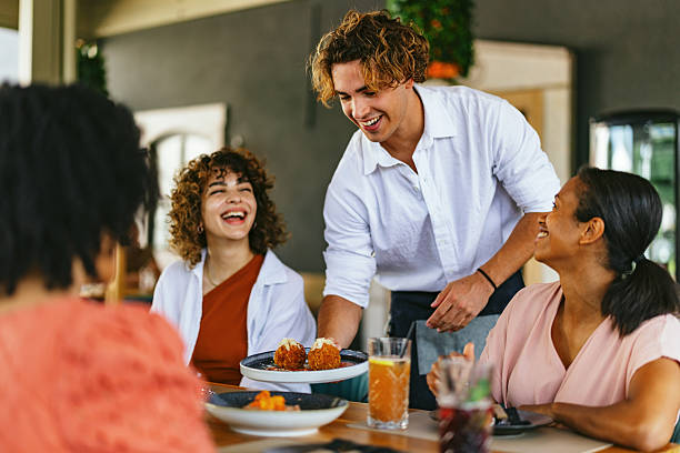 istock Friends Laughing and Enjoying Meal at Restaurant 2220301258
