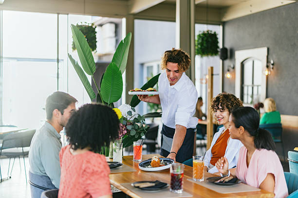 istock Friends Enjoy Meal and Drinks in a Cozy Restaurant Setting 2220301268