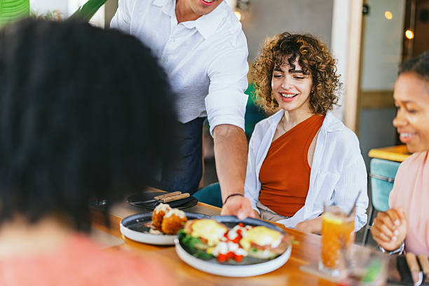istock Friends Enjoying Meal and Drinks at Restaurant 2220301295