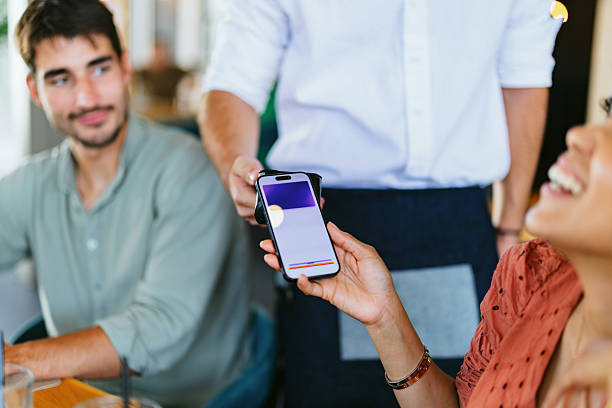 istock Friends Enjoying Meal and Making Digital Payment in Restaurant 2220301408