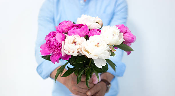 istock Man Holding/Offering Bouquet of Peonies 2220310263
