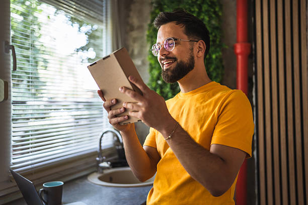 istock Delight happy caucasian man with package in the kitchen 2220310552