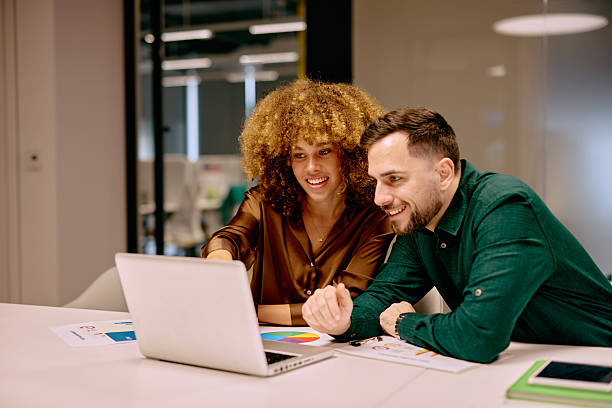 istock Two Young Happy Business Colleagues Working on Laptop in Office 2220311642