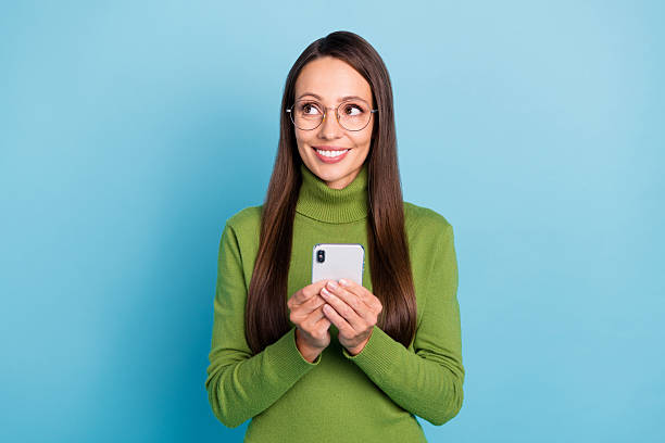istock Photo of dreamy shiny lady dressed turtleneck spectacles chatting modern gadget looking empty space isolated blue color background 2220311649