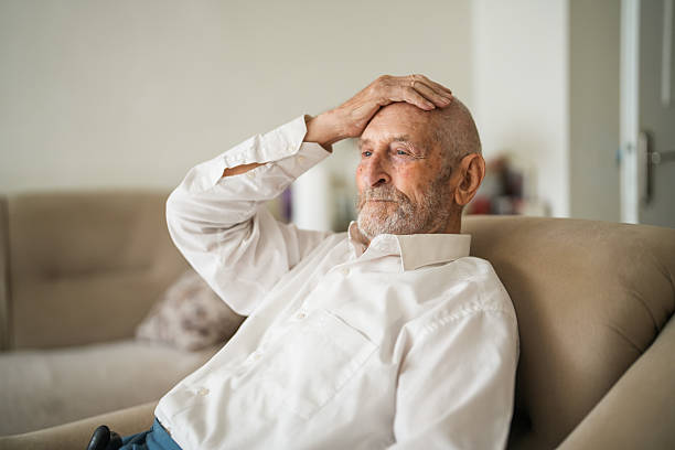 istock Lonely Elderly Man Sitting Thoughtfully at Home with Walking Cane 2220311949