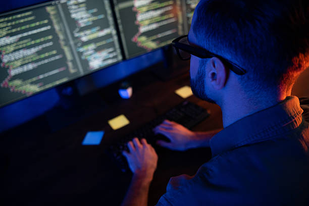 istock Close up cropped rear back portrait of young developer texting typing improving database late house dark room 2220312966