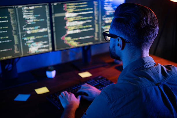 istock Rear back portrait of skilled young tester look two displays write typing working night dark loft room 2220313001