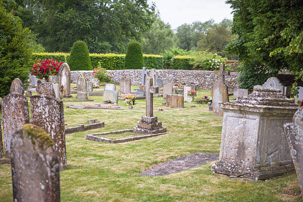 Old English cemetery with weathered gravestones covered in moss and lichen. Peaceful rural graveyard, UK.  No identifiable gravestones.