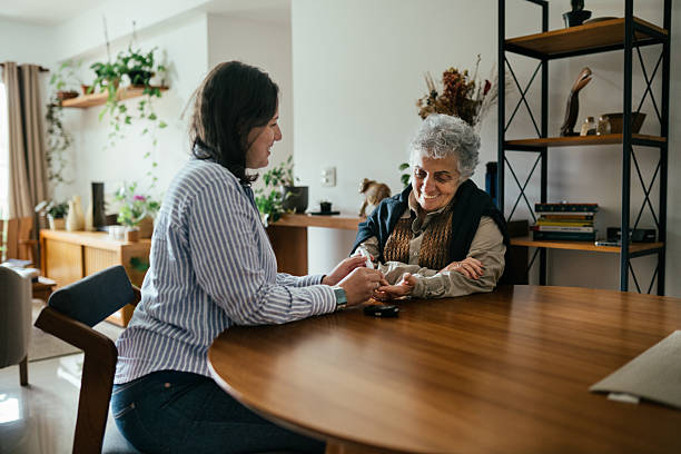 istock Caregiver checking senior woman's glucose with glucometer 2220313984