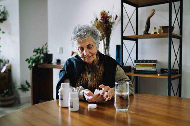 istock Senior woman taking medication at home 2220314009