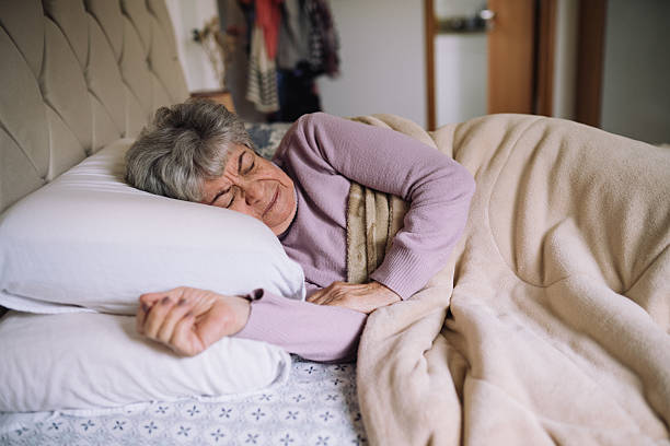 istock Senior woman sleeping peacefully in bed 2220314029