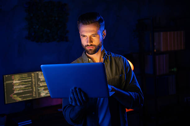 istock Portrait of clever intelligent skilled person hold netbook testing algorithms dark space business center 2220314782