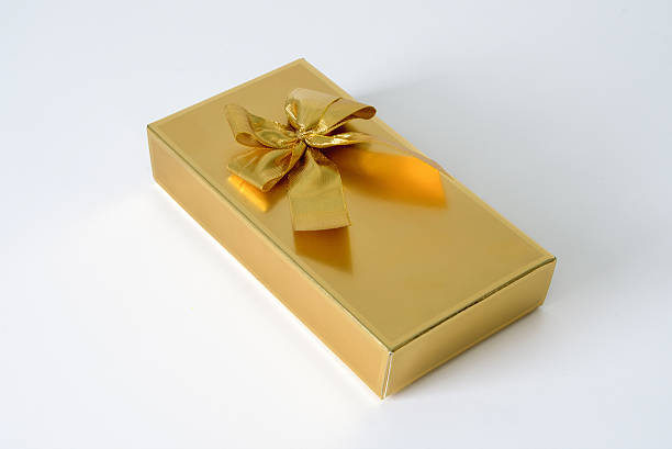 istock A gold box with a bow on top of it. Close up 2220318921