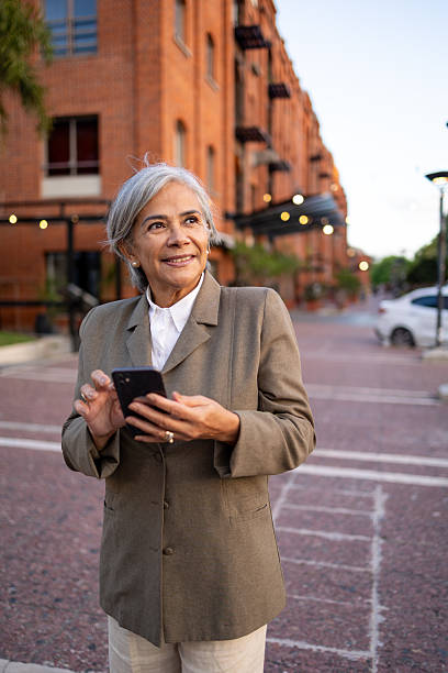 istock Mature businesswoman using a smartphone outdoors in an urban setting 2220320318