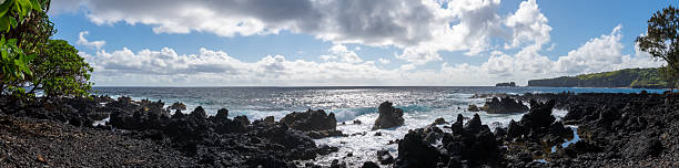istock Panoramic view of a rocky beach with crashing waves under a cloudy sky. 2220328528