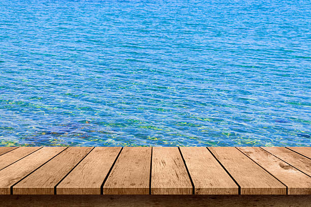 wooden table top with blue sea summer background.