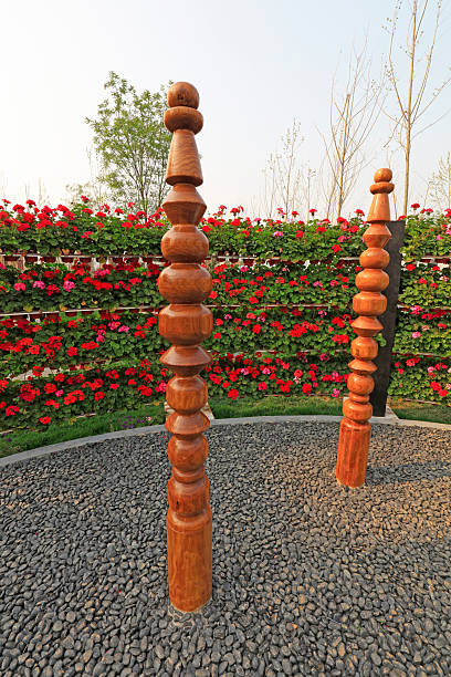 Cozy natural setting in a K. Dineikos Wellness Park, Druskininkai, Lithuania. It features lawn with roses, tall pine trees and a clear pathway leading towards a wooden pavilion.