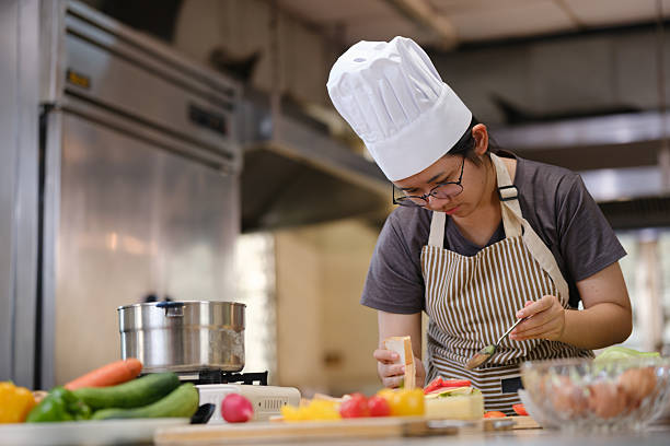 istock Focused chef carefully a gourmet sandwich in a professional kitchen with fresh ingredients in view 2220336540