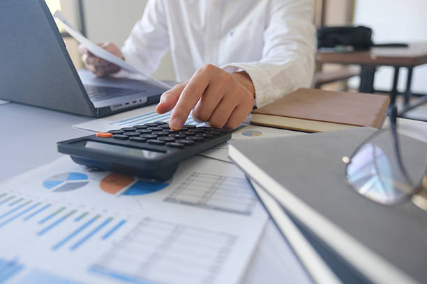 istock Close up accountant banker or bookkeeper making calculations with calculator. 2220337949