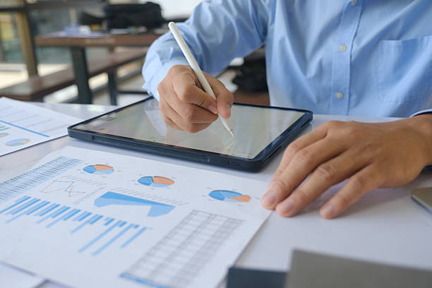 istock Businessman analyzing financial data on tablet with stylus during office meeting. 2220337953