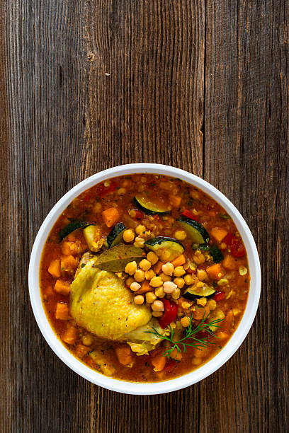 istock Fresh vegetable soup with lentil, chickpea and chicken on wooden table 2220338278