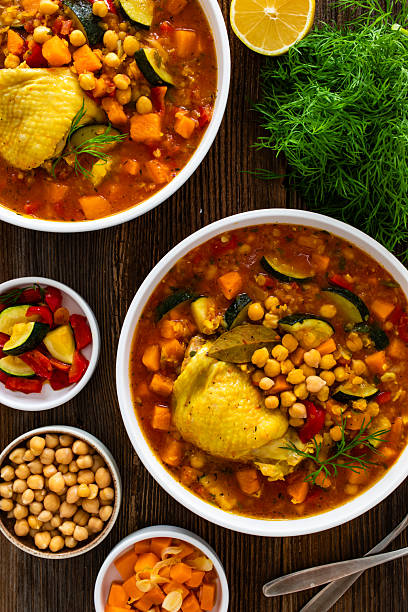 istock Fresh vegetable soup with lentil, chickpea and chicken on wooden table 2220338320
