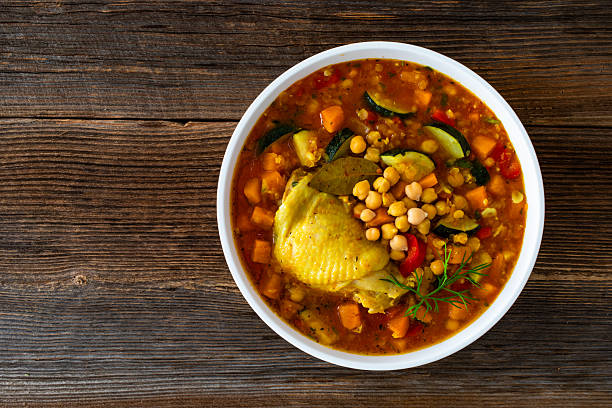 istock Fresh vegetable soup with lentil, chickpea and chicken on wooden table 2220338333