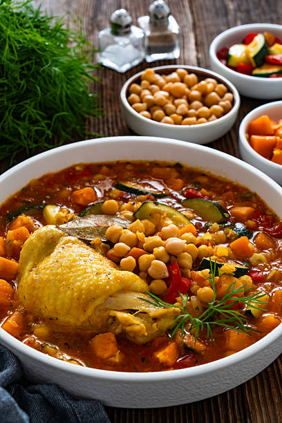 istock Fresh vegetable soup with lentil, chickpea and chicken on wooden table 2220338355
