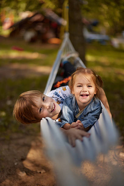 istock Happy little siblings enjoying in hammock at the backyard. 2220344433