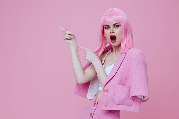 Young positive woman gestures with his hands with a pink jacket Studio Model unaltered. High quality photo