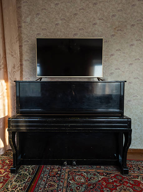 istock Black piano standing in a room with a flat screen 2220349712