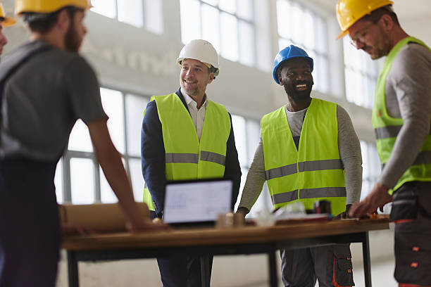 istock Happy architect having a meeting with his workers at construction site. 2220351226