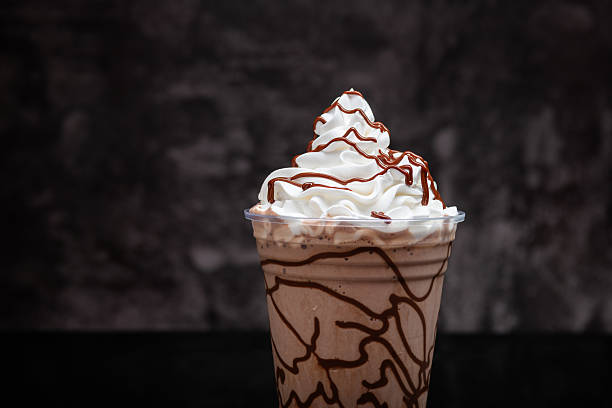 istock Chocolate milkshake served in a clear glass on a dark background. Isolated drink 2220353356