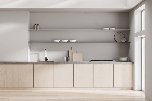 istock Minimalist Scandinavian kitchen interior with light wood cabinets, concrete countertop, open shelving, and soft natural daylight illumination. 3D Rendering 2220355461