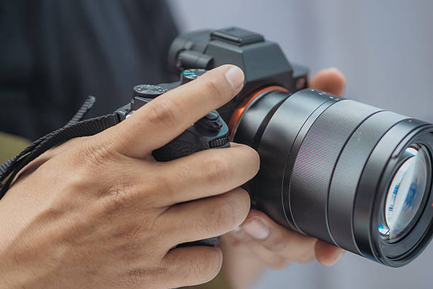 istock close up of hand holding mirrorless camera 2220355780