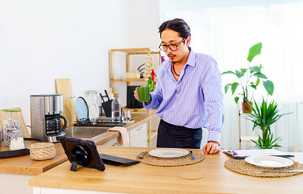 istock Remote work from home, video call and man with a laptop, internet connection or conference call. Male person, entrepreneur or speaker with a pc, conversation or webinar with conversation in a kitchen 2220359352