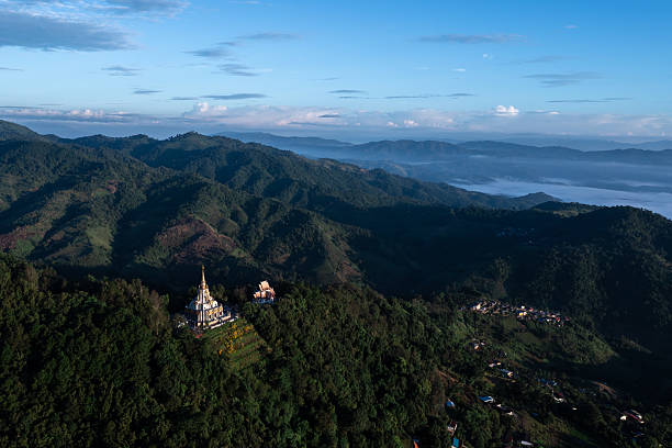 istock aerial view shows a beautiful temple nestled on a forested hillside, surrounded by mountain ranges and a tranquil morning mist. 2220365457