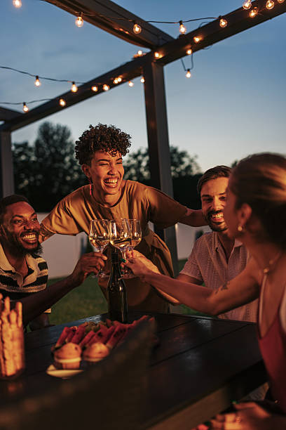 istock Friends toasting with white wine at a summer evening party 2220370402