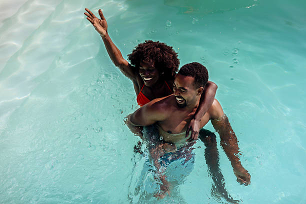 istock Playful Couple Embracing in Pool 2220376047