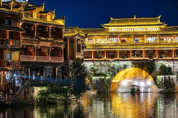 Night scene of traditional tourist boat in Fenghuang ancient city in Hunan, China. stock photo