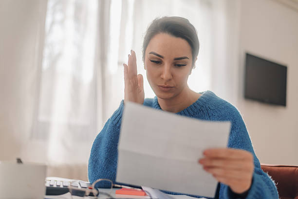 istock Stressed woman reading a bill and gesturing frustration at home 2220379127