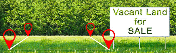 istock Land plot management - real estate concept with a vacant land on a green field available for building construction - concept with advertising billboard and Vacant Land For Sale text 2220380979