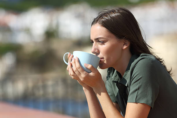 istock Woman in a balcony drinking coffee on the beach 2220381471